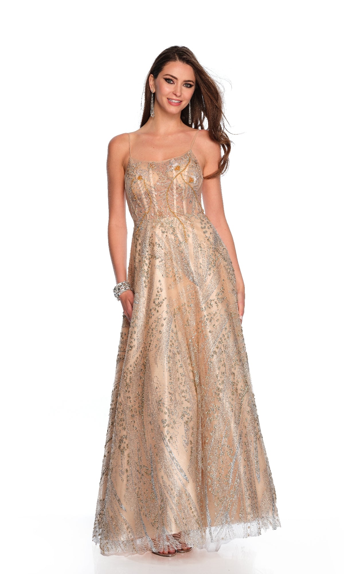 A woman wears the Dave & Johnny 11534 long gold prom dress, featuring sparkling sequin patterns on nude mesh. She stands smiling against a plain white background—a stunning choice for prom night.